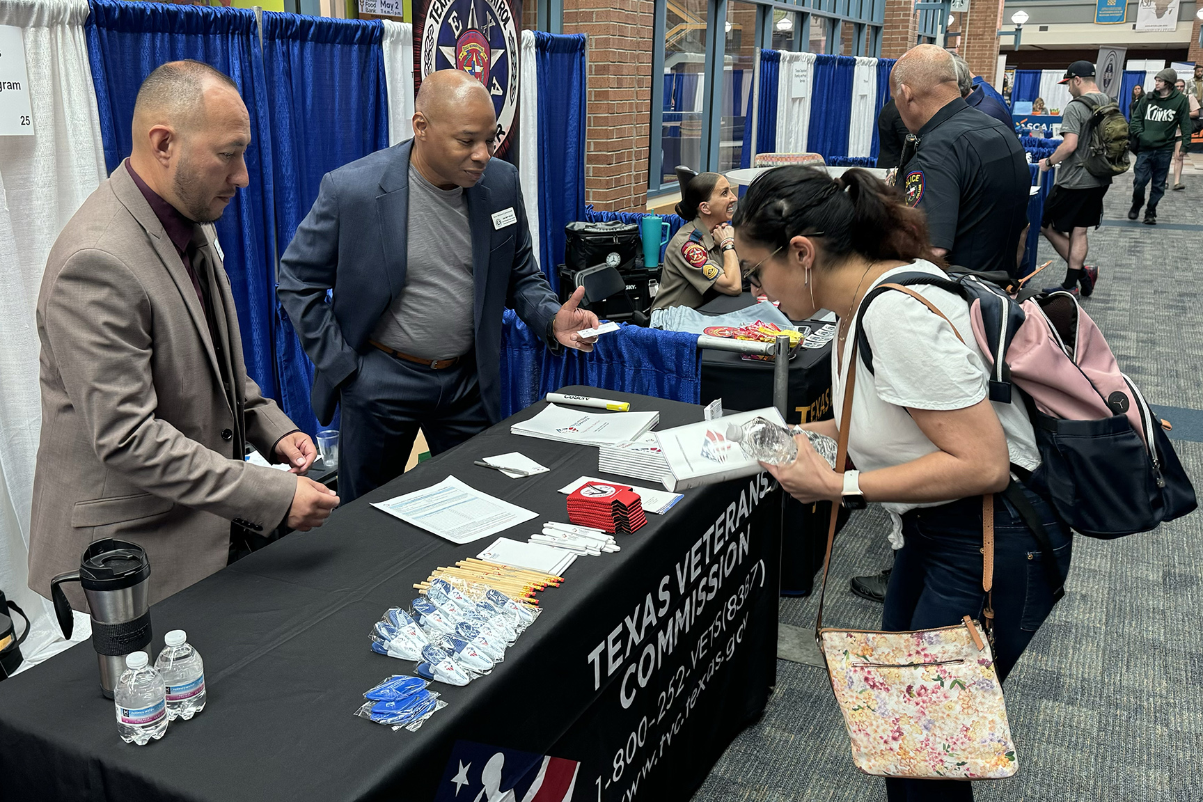 A job seeker has a discussion with representatives from the Texas Veterans Commission.