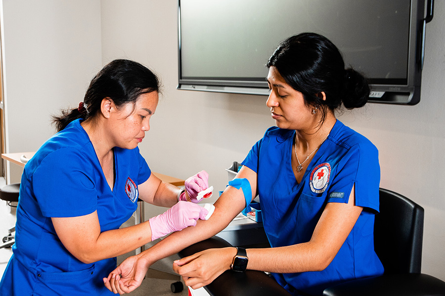 Students in the Medical Assist program learn to draw blood for a course. 