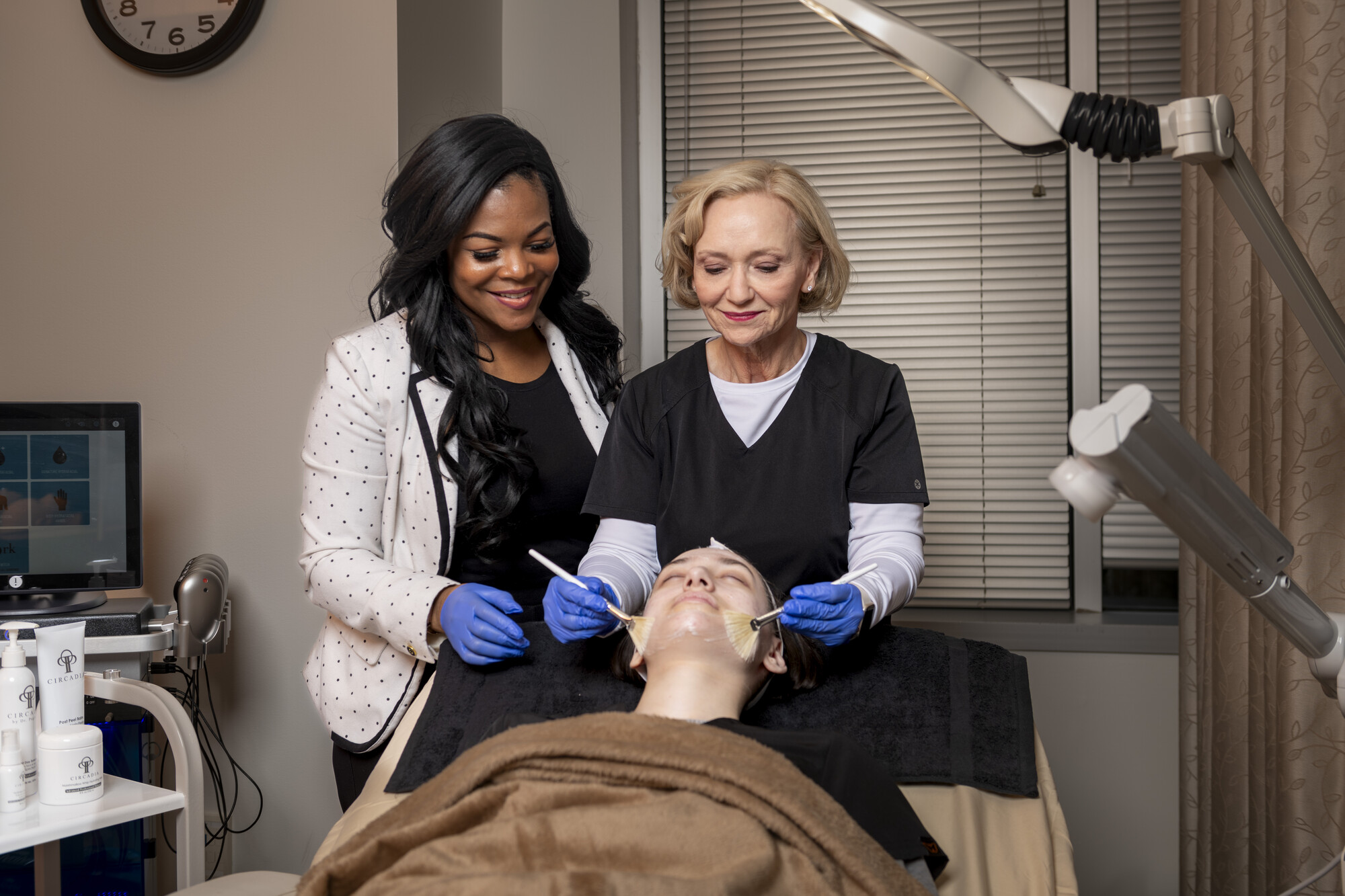 An esthetician student and her trainer work on a volunteer