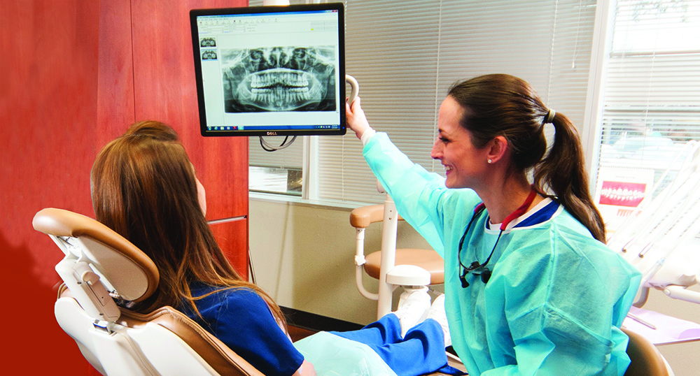 A Collin College dental hygiene student works with a client.